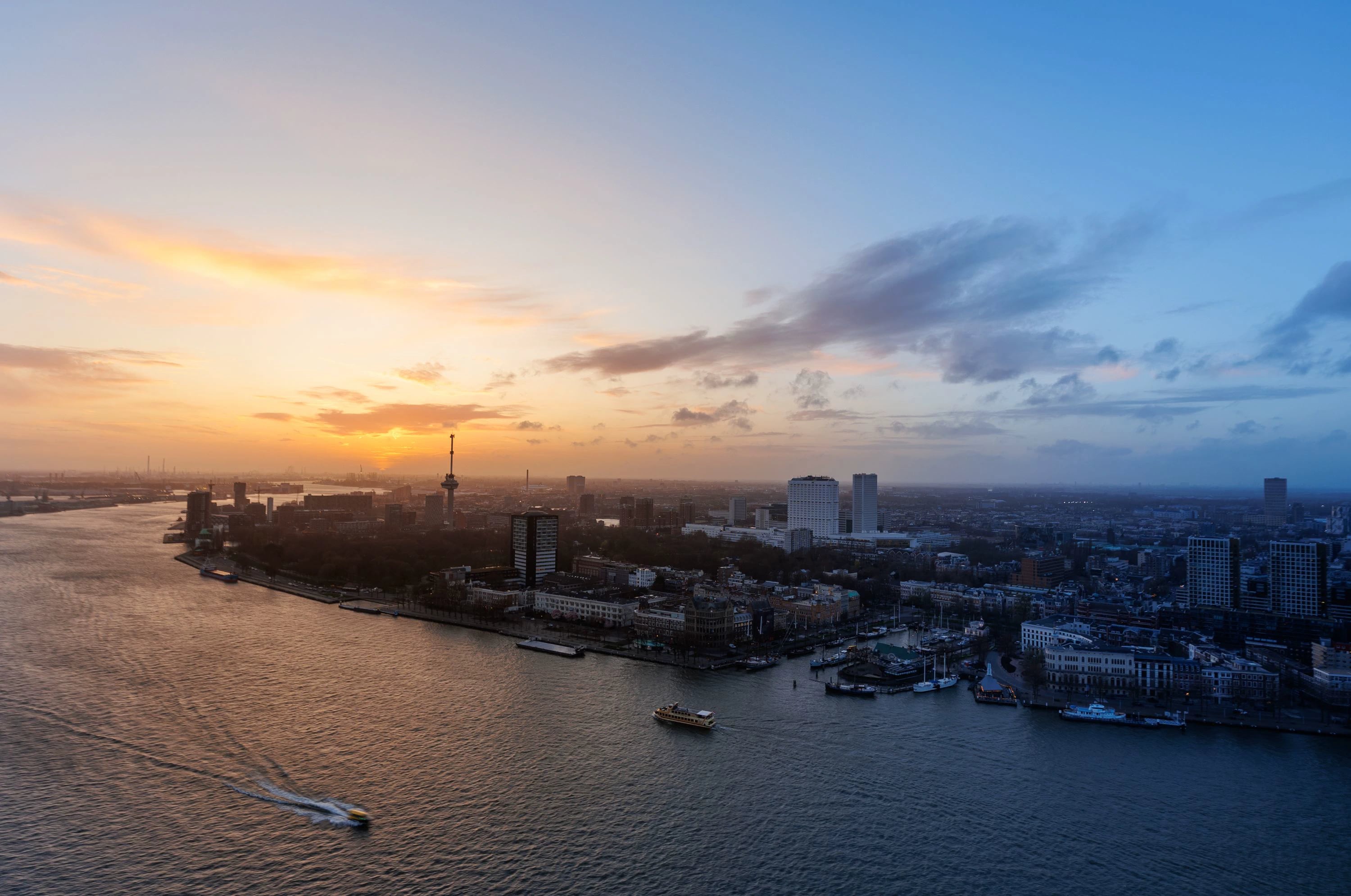 Luchtfoto van Rotterdam en de Maas in het blauwe uur.